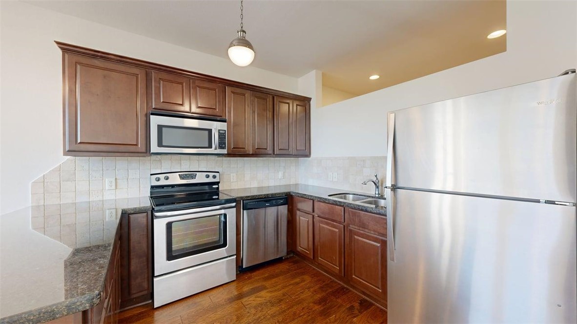 206 North Main Street, Unit 123 Bryan, TX 77803 - Photo 7 of 19 a kitchen with a refrigerator a stove top oven a sink and dishwasher