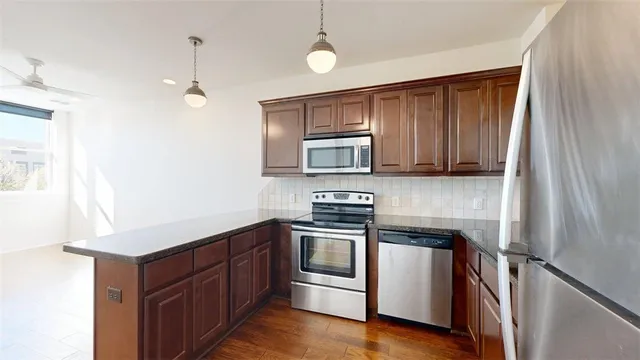 a kitchen with stainless steel appliances granite countertop a stove a sink and a microwave