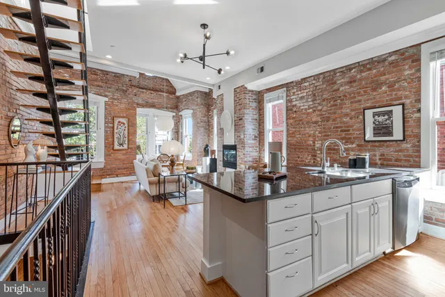 a large kitchen with stainless steel appliances granite countertop a lot of counter space and wooden floors