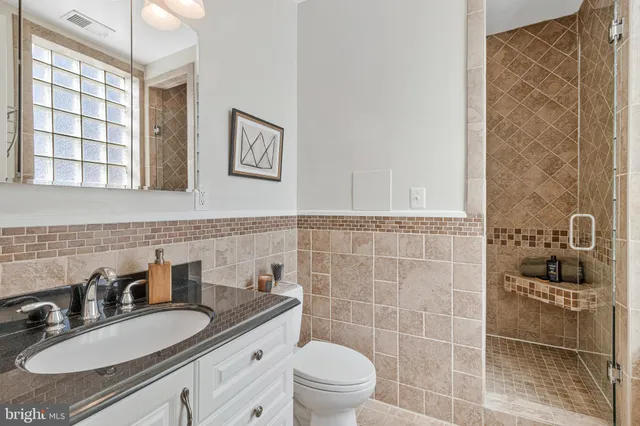 a bathroom with a sink a toilet and a mirror