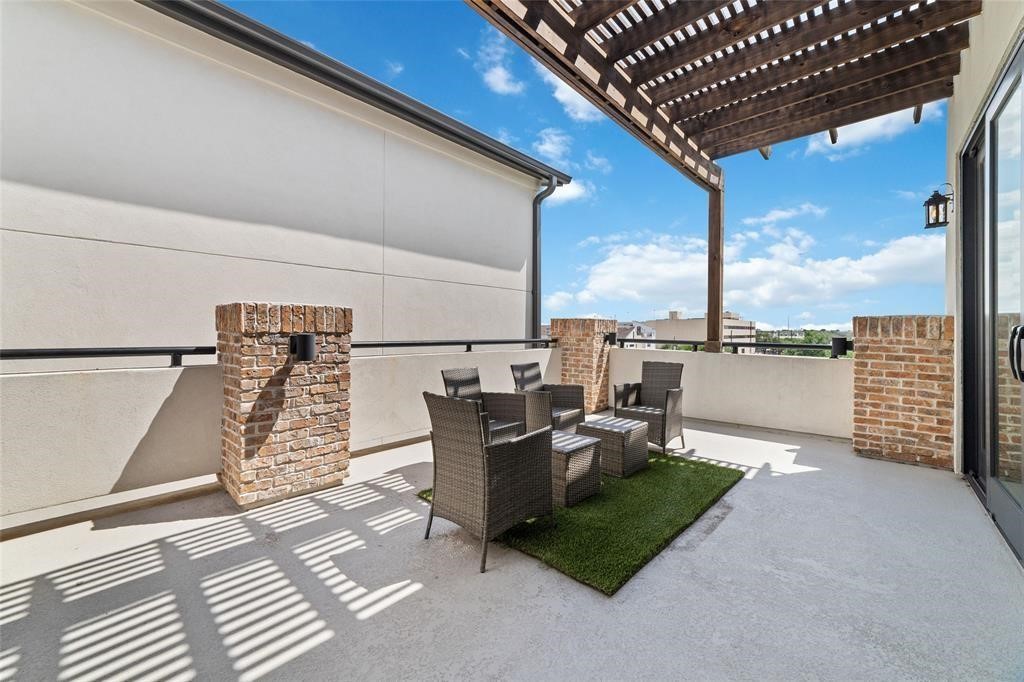 710 Delano Street, Unit A Houston, TX 77003 - Photo 26 of 32 Spacious rooftop patio with a wooden pergola, brick accents ideal for relaxing or entertaining, with a mix of sun and shade.