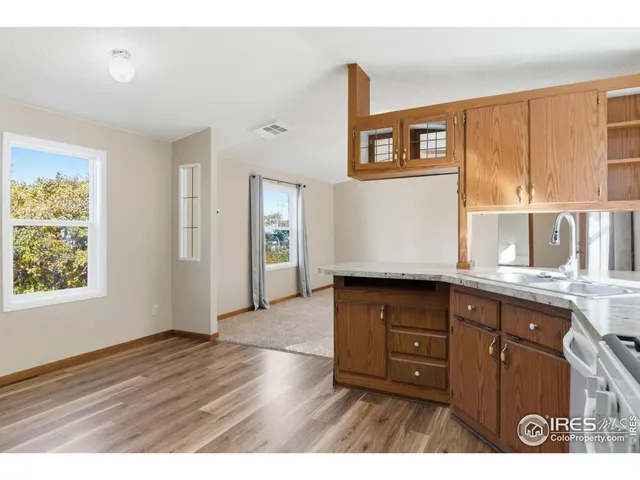 a kitchen with granite countertop wooden floors and wide window