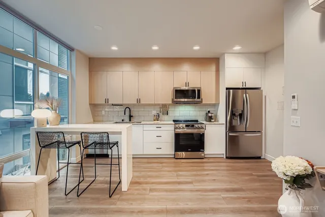 a kitchen with refrigerator a sink and chairs