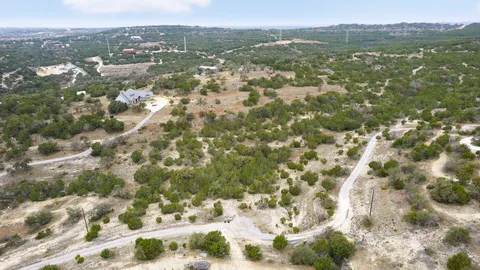 an aerial view of residential houses with outdoor space and trees