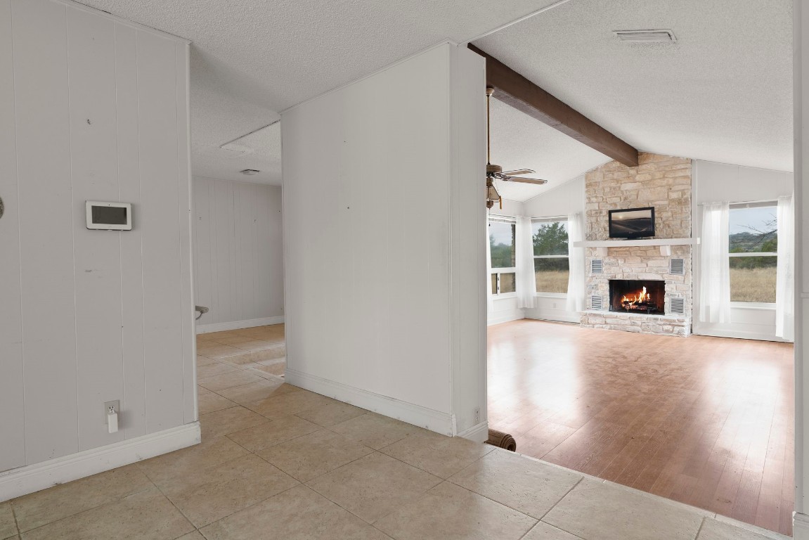21418 Kathy Lane Spicewood, TX 78669 - Photo 8 of 40 an empty room with wooden floor and a fireplace