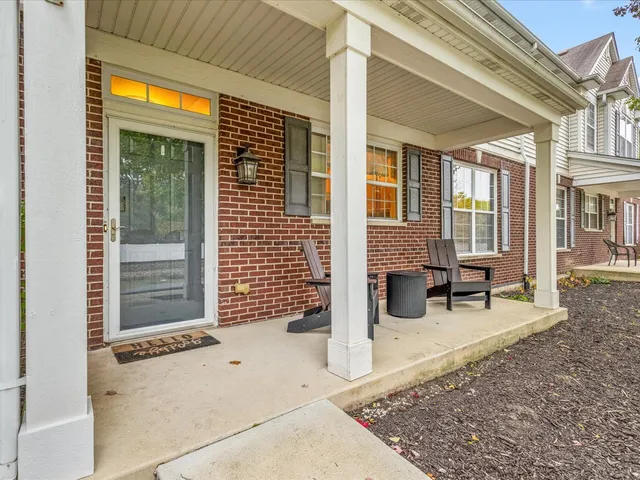 a view of a brick house with large windows and wooden fence