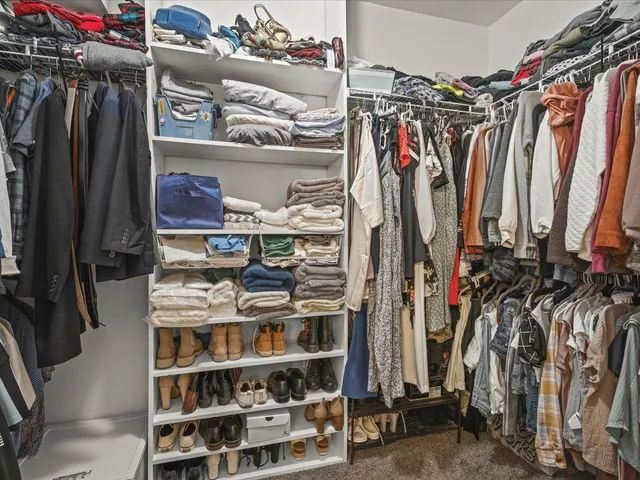 a view of walk in closet with clothes and shoes