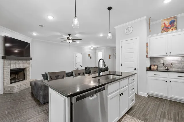 a open kitchen with stainless steel appliances granite countertop a sink a stove and a wooden floor