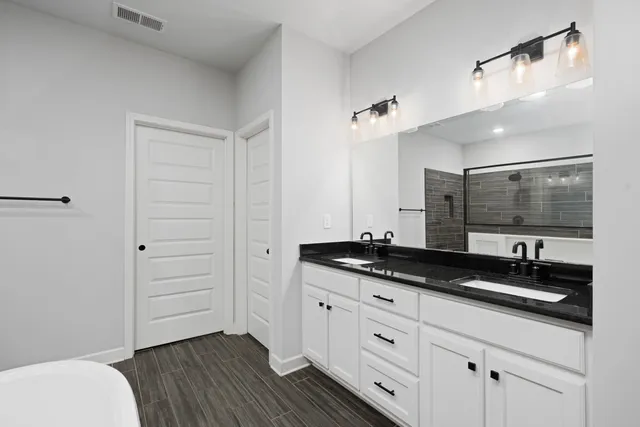 a bathroom with a granite countertop sink a toilet a mirror and vanity