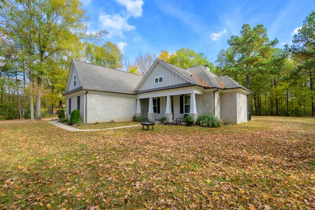 a view of a house with a yard and large tree