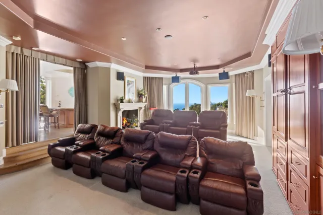 a media room with lots of chairs and a chandelier