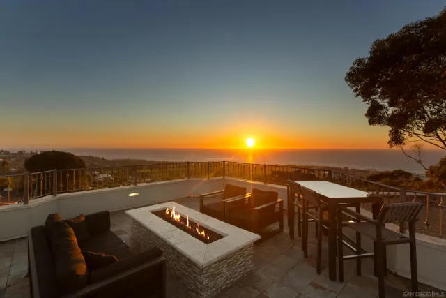 a view of a roof deck with couches and sky view