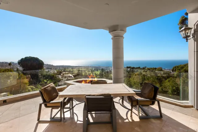 a balcony with table and chairs