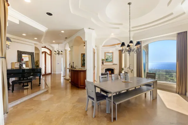 a living room with couches a table and chairs with wooden floor
