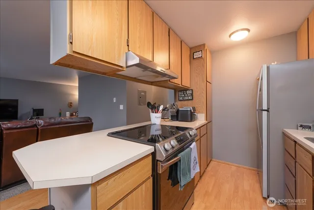 a kitchen with stainless steel appliances granite countertop a sink a stove and a refrigerator