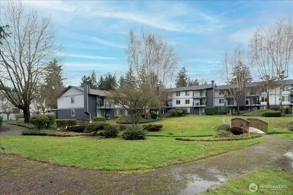 a front view of a house with a garden and trees