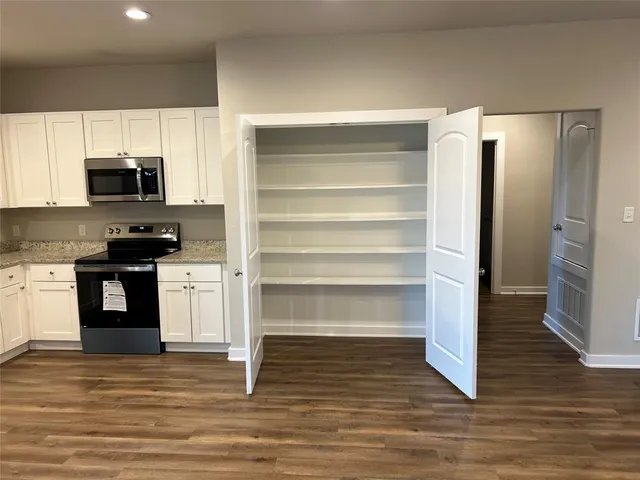a view of an empty room with wooden floor