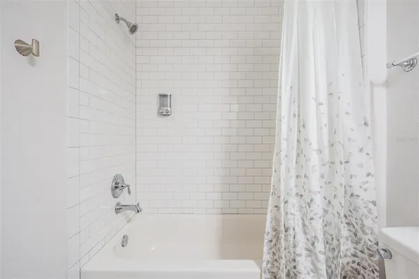 a bathroom with a granite countertop toilet a sink and a bathtub