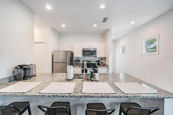 a kitchen with stainless steel appliances granite countertop a sink and a stove