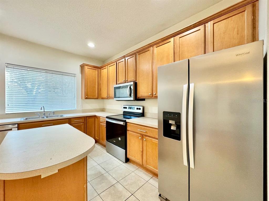 10545 Shady Falls Court Riverview, FL 33578 - Photo 11 of 36 a kitchen with stainless steel appliances granite countertop a refrigerator a stove and a sink with cabinets