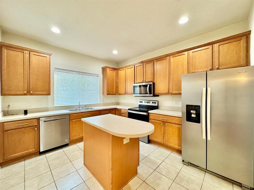 10545 Shady Falls Court Riverview, FL 33578 - Photo 8 of 36 a kitchen with stainless steel appliances granite countertop a sink a stove a refrigerator and cabinets