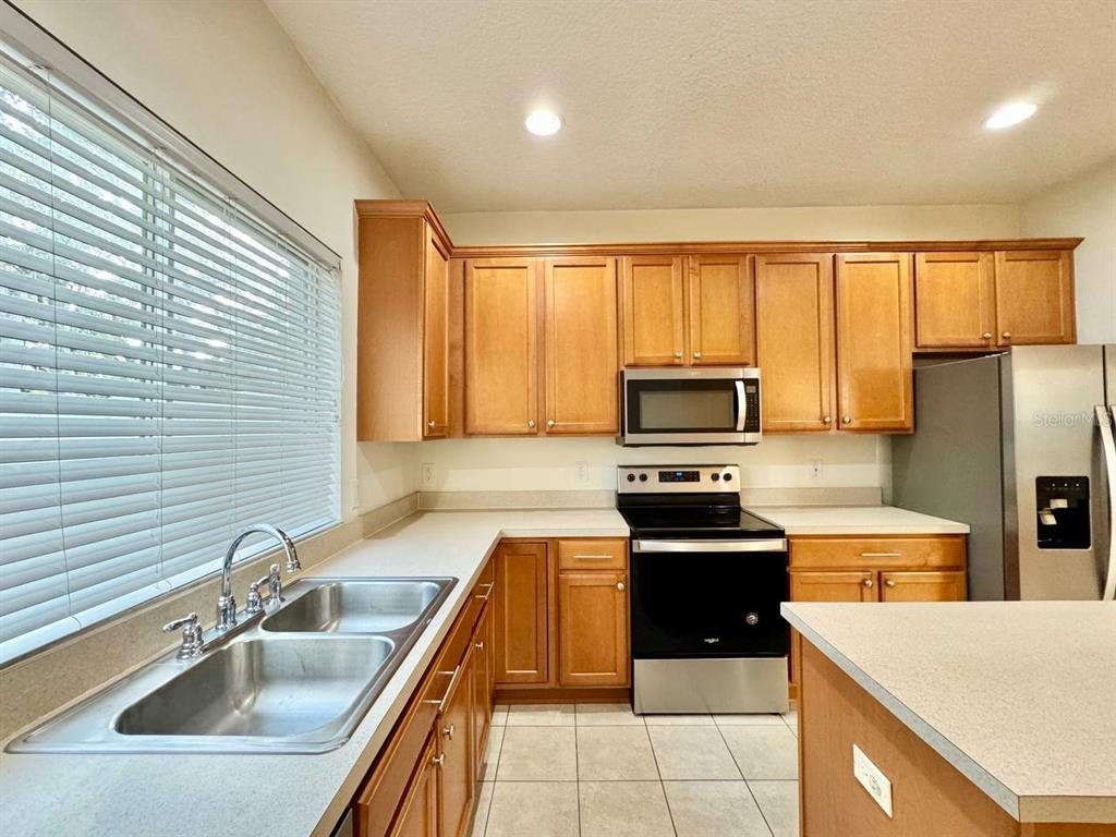 10545 Shady Falls Court Riverview, FL 33578 - Photo 9 of 36 a kitchen with a sink a stove top oven and refrigerator
