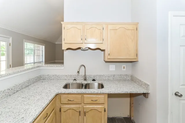 an empty room with chandelier fan and windows