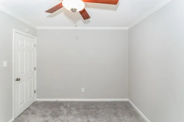 an empty room with a window and a ceiling fan