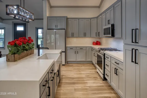 a kitchen with stainless steel appliances a dining table chairs and refrigerator