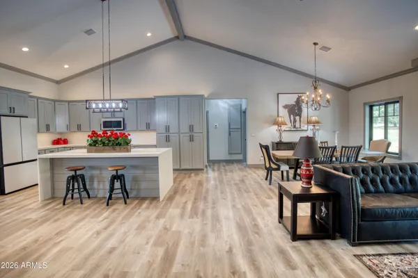 a kitchen with stainless steel appliances kitchen island granite countertop a refrigerator a stove top oven a sink and dishwasher