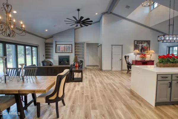 a kitchen with kitchen island a dining table chairs cabinets and stainless steel appliances