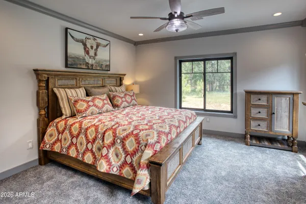 a bed sitting in a spacious bedroom next to a window