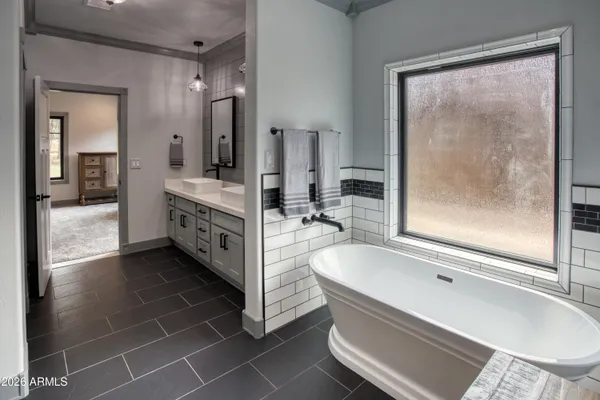 a bathroom with a tub a sink and a mirror