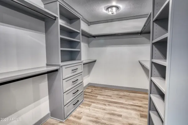 a view of walk in closet with empty racks