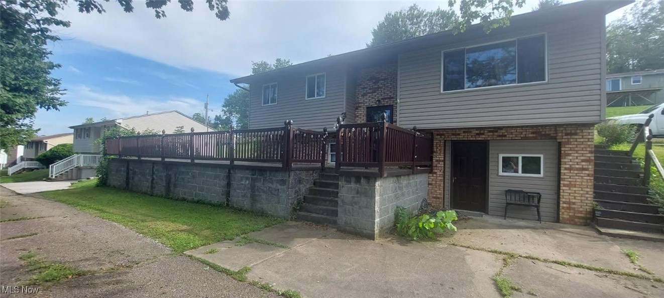7 Montenery Road Rayland, OH 43943 - Photo 1 of 29 Rear view of property with stairs, brick siding, a deck, and a garage