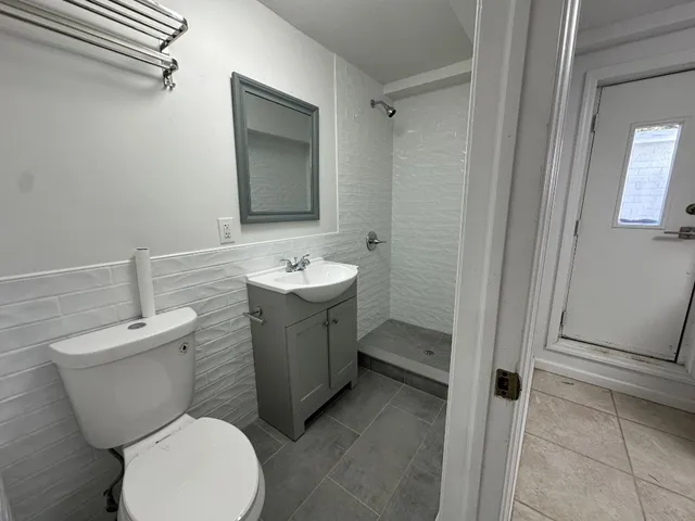 a bathroom with a toilet a sink and mirror