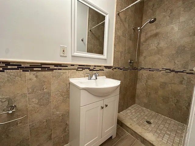 a bathroom with a sink mirror and shower
