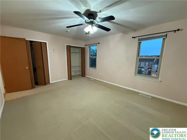 a view of an empty room with a ceiling fan