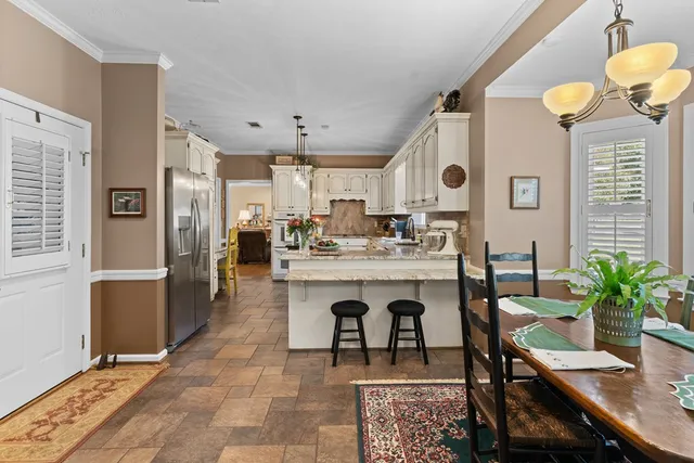a dining room with furniture a chandelier and wooden floor