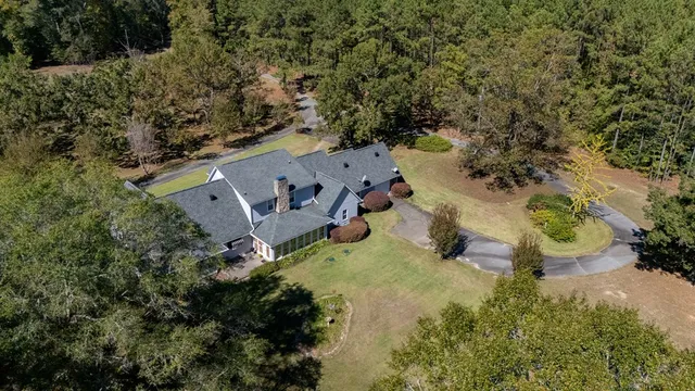 an aerial view of a house with a yard and lake view