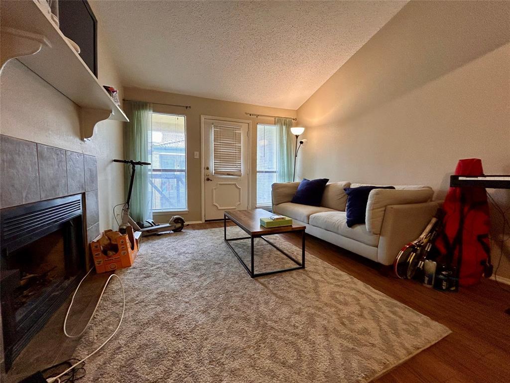 806 West 24th Street, Unit 233 Austin, TX 78705 - Photo 2 of 5 a living room with furniture a flat screen tv and a fireplace