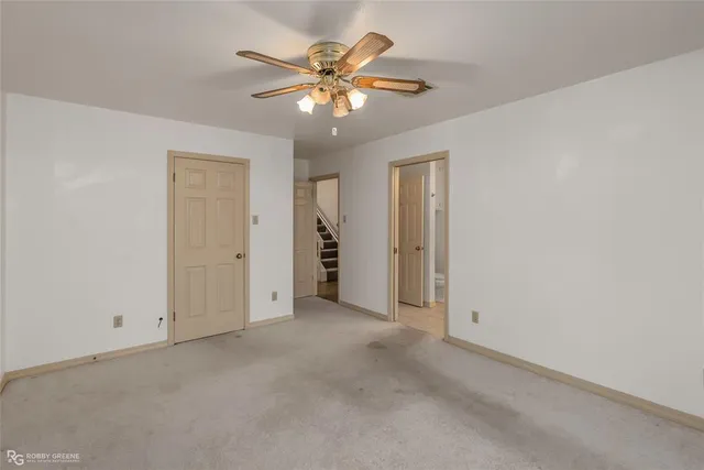 an empty room with closet and a chandelier fan