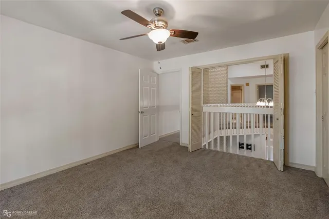 a view of an empty room with a ceiling fan