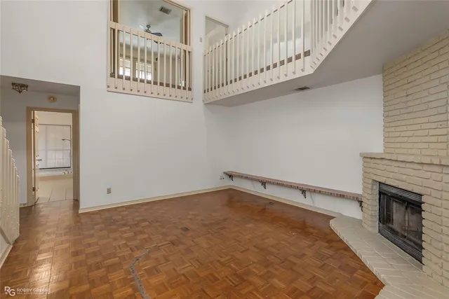 a view of an empty room with stairs and a fireplace