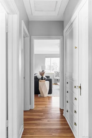 a hallway with white cabinets and wooden floor