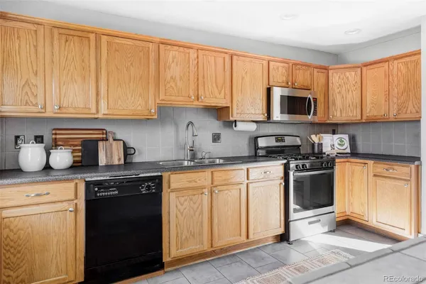 a kitchen with stainless steel appliances granite countertop white cabinets sink and a granite counter top
