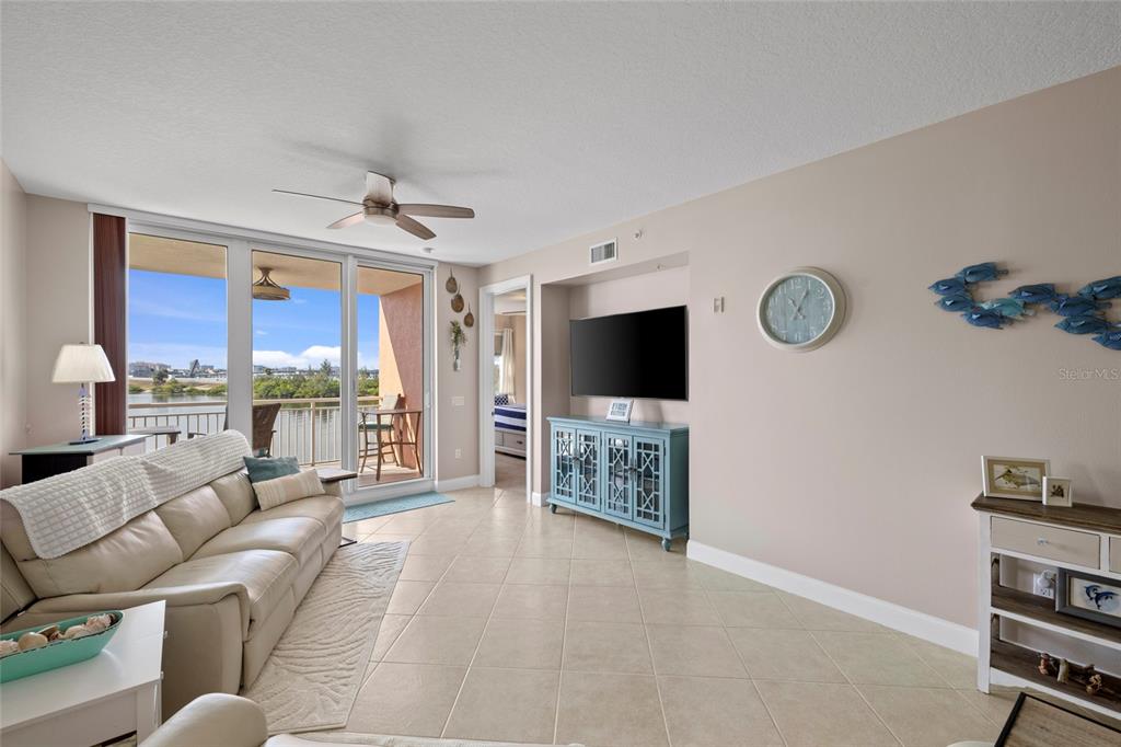 615 Riviera Dunes Way, Unit 204 Palmetto, FL 34221 - Photo 13 of 43 a living room with furniture a flat screen tv and kitchen view