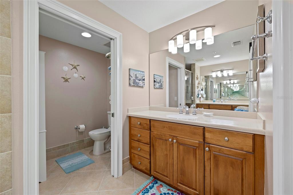 615 Riviera Dunes Way, Unit 204 Palmetto, FL 34221 - Photo 22 of 43 a spacious bathroom with a granite countertop sink a toilet and a mirror