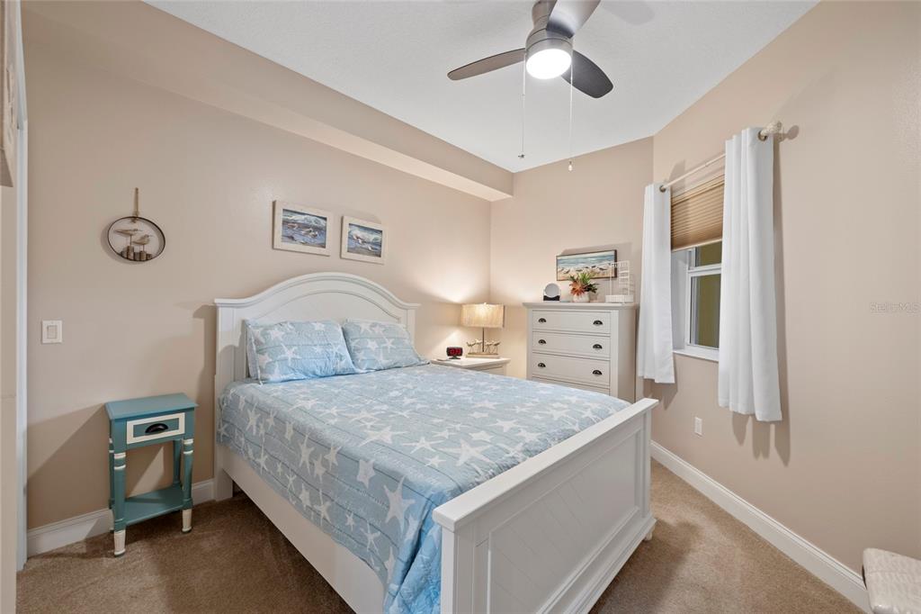 615 Riviera Dunes Way, Unit 204 Palmetto, FL 34221 - Photo 24 of 43 a bedroom with a bed and a chandelier