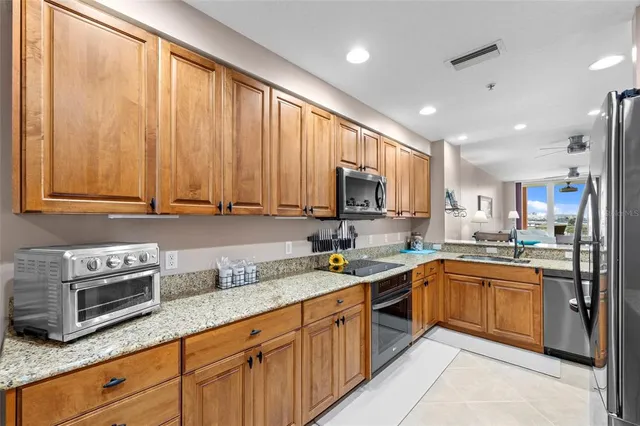 a kitchen with stainless steel appliances granite countertop a sink stove and microwave
